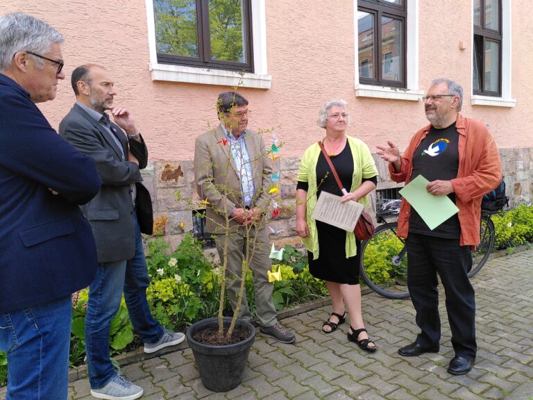 Im Mai 2022 übergaben Brigitte Schlupp-Wick und Wolfgang Schlupp-Hauck den Gingko-Setzling an die BUGA-Gesellschaft. der dann im Nachhaltigkeitsgarten für das SDG 16 eingepflanzt wird